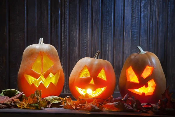 Cara de calabaza de Halloween Jack o linternas sobre fondo de madera — Foto de Stock