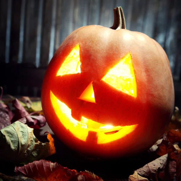 Jack o Laternen Halloween Kürbisgesicht auf Holzgrund — Stockfoto