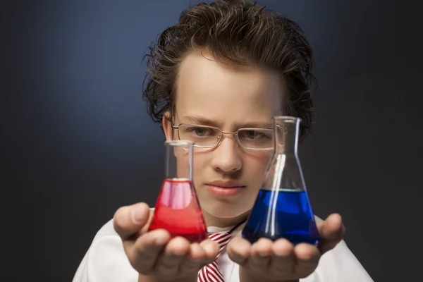 Boy studying a substance in a retort — Stock Photo, Image