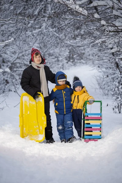 Drei glückliche Jungen mit Schlittenspiel — Stockfoto