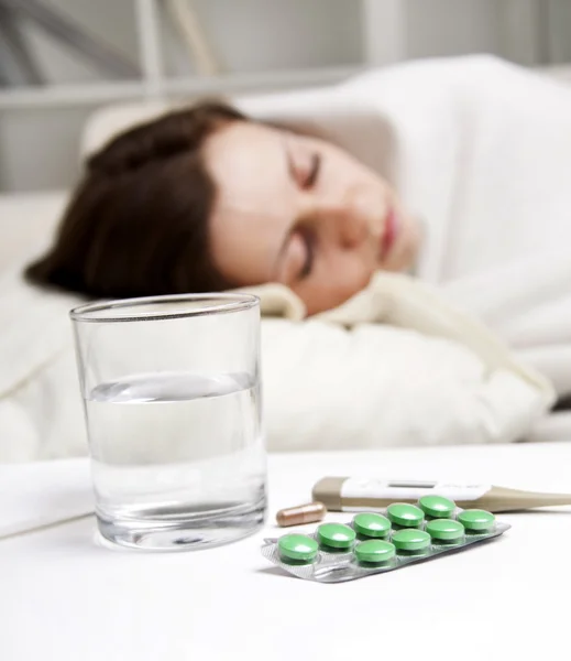 Menina deitada perto de medicamentos doentes — Fotografia de Stock
