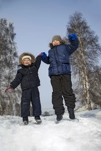 Heureux garçons sauter en hiver à l'extérieur — Photo