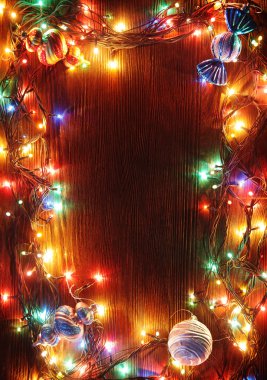 Ahşap arka plan üzerinde lambaların Noel çelenk.