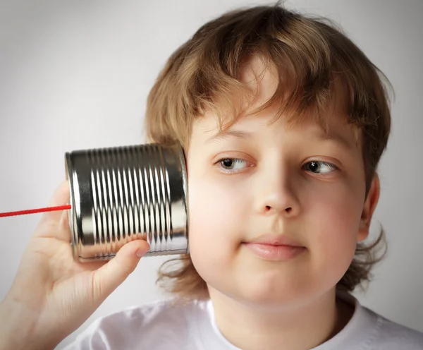 Krása chlapec poslouchat plechovkový telefon — Stock fotografie