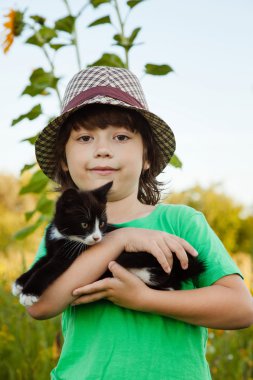 Bir yavru kedi ile mutlu çocuk