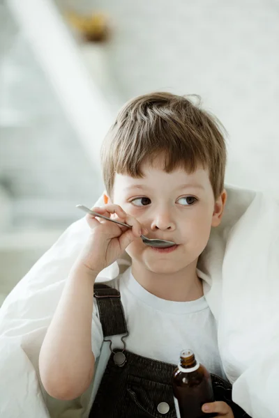 Мальчик пьет сироп от кашля — стоковое фото