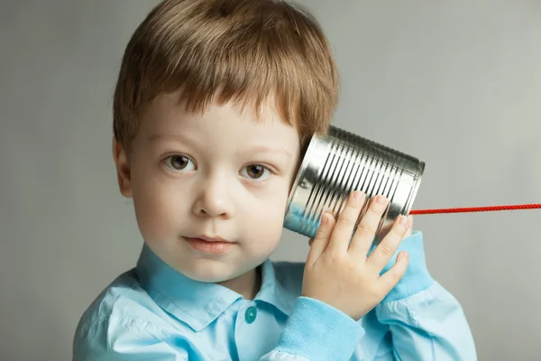 Ragazzo ascolta stagno può telefono — Foto Stock