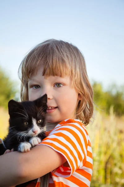 Niño feliz con un gatito — Foto de Stock