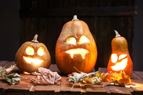 Jack o lanterns Halloween pumpkin face on wooden background — Stock Photo, Image