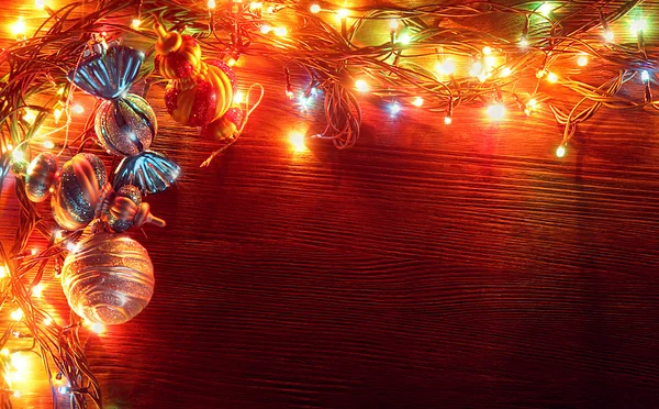 Рождественские гирлянды из ламп на деревянном фоне . — стоковое фото