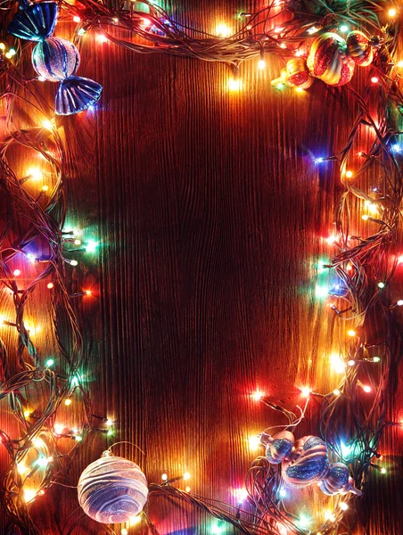 Guirnaldas de Navidad de lámparas sobre fondo de madera . —  Fotos de Stock