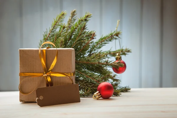 Árbol de Navidad con caja de regalo y decoraciones sobre fondo de madera — Foto de Stock