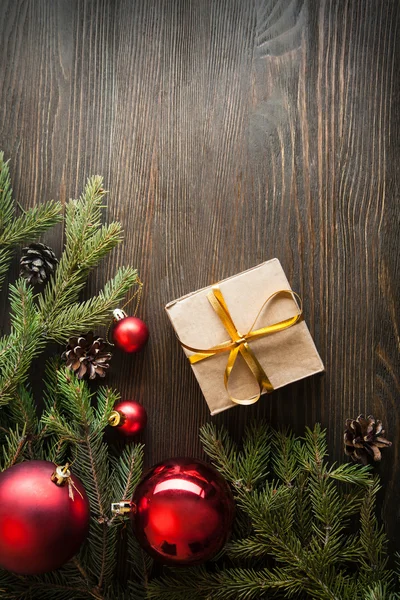 Kerstboom met doos van de gift en decoraties op houten pagina — Stockfoto