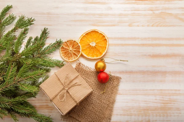 Weihnachtsbaum mit Geschenkschachtel und Dekorationen auf hölzernem Hintergrund — Stockfoto