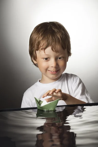 Jongen spelen in papier schip — Stockfoto