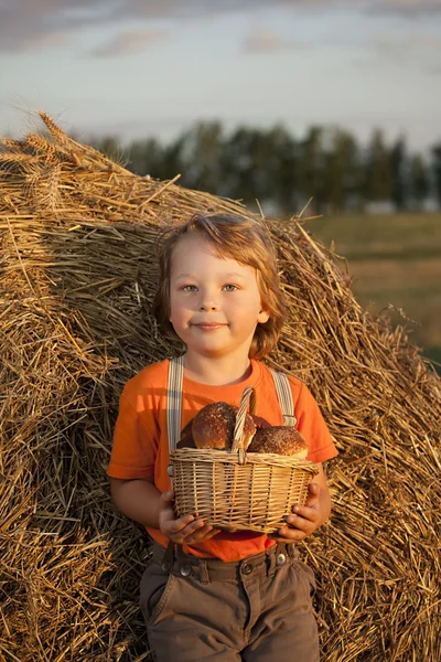 Мальчик с корзиной булочек — стоковое фото