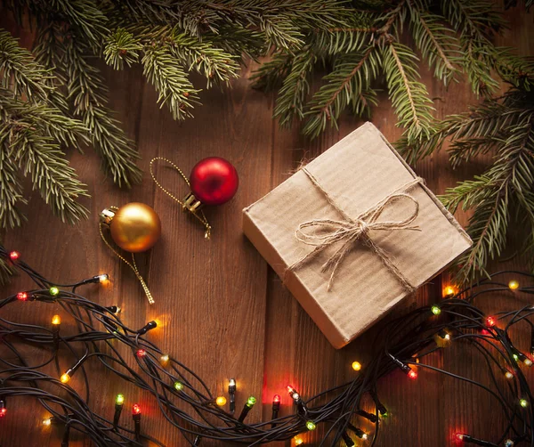 Árbol de Navidad con caja de regalo y decoraciones sobre fondo de madera — Foto de Stock