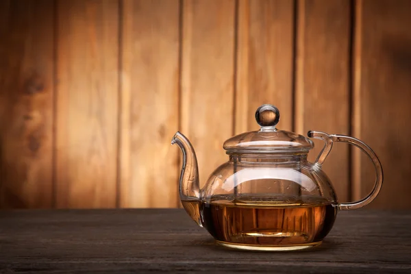 Tetera y taza de té sobre mesa de madera —  Fotos de Stock