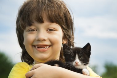 Bir yavru kedi ile mutlu çocuk