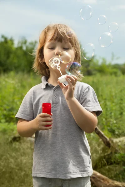 Boy play in bubbles — Stock Photo, Image