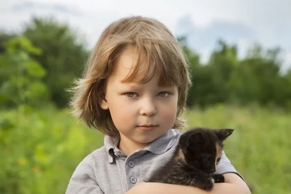 Niño feliz con un gatito — Foto de Stock