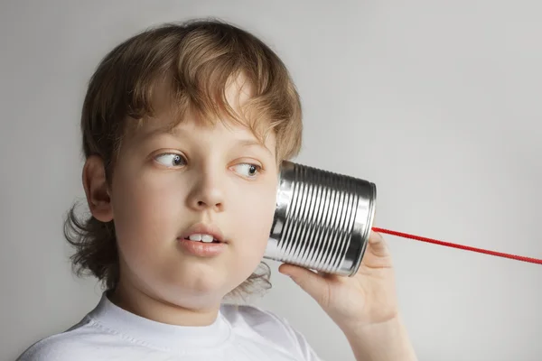 Мальчик слушать жестянка может телефон — стоковое фото
