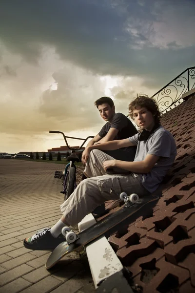 Dois adolescentes conversando no parque sobre esportes radicais — Fotografia de Stock