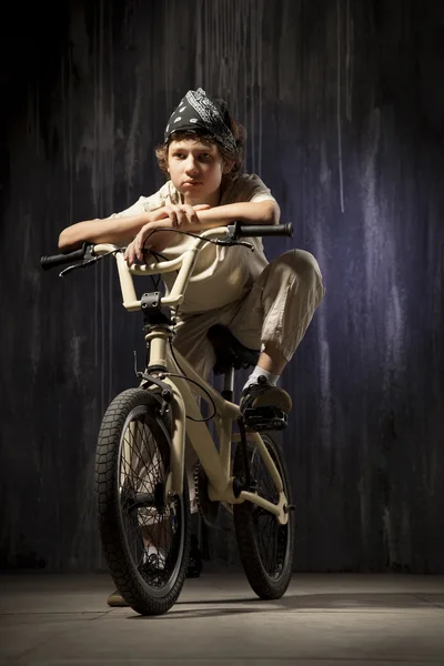 Adolescent sur un vélo sur un fond de paysage industriel — Photo