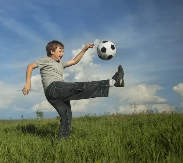 Glücklicher Junge spielt Fußball lizenzfreie Stockfotos