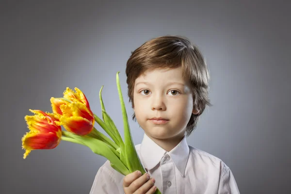 Cheerful kid with a bouquet of tulips — Stock Photo, Image