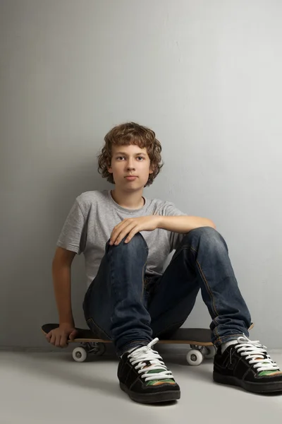 happy boy sitting on skateboard