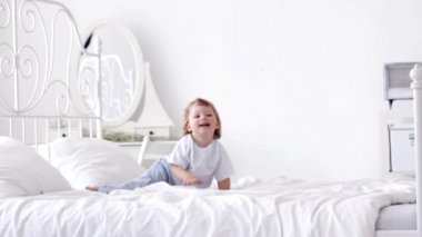 neşeli yürümeye başlayan çocuk takla yatakta