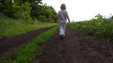 Kırsal bir yolda yürürken mutlu çocuk