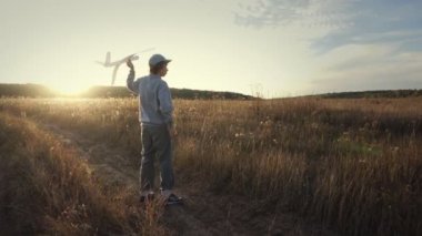 Mutlu çocuk oynarken bir çayır uçakta ile