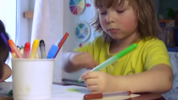 Niños dibuja en la mesa en casa — Vídeo de stock