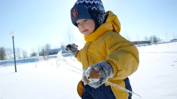 Kind spelen met icicle in de winter — Stockvideo