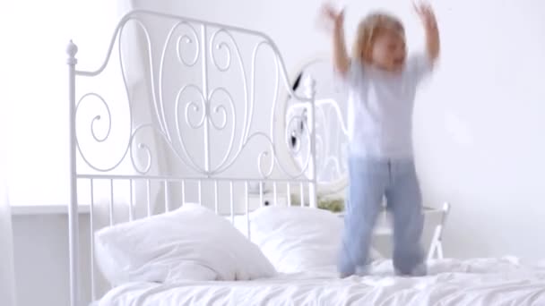 Vrolijke jongen springen op het bed — Stockvideo