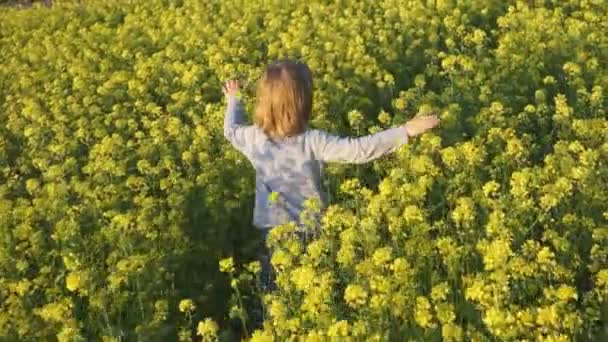 Criança correndo através de um prado de flores — Vídeo de Stock