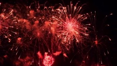 4K. Gerçek havai fişek arka planı. Gece gökyüzünde parlayan havai fişekler. Işıl ışıl parlıyor. Yeni yıl arifesi havai fişek kutlaması. Renkli Yeni Yıl Havai fişekleri