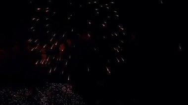 4K. Gerçek havai fişek arka planı. Gece gökyüzünde parlayan havai fişekler. Işıl ışıl parlıyor. Yeni yıl arifesi havai fişek kutlaması. Renkli Yeni Yıl Havai fişekleri