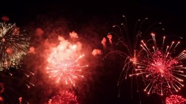 4K. Gerçek havai fişek arka planı. Gece gökyüzünde parlayan havai fişekler. Işıl ışıl parlıyor. Yeni yıl arifesi havai fişek kutlaması. Renkli Yeni Yıl Havai fişekleri