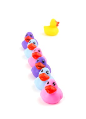 Lastik ördek üst üste, bir ters yönde başlı, kayboluyor - kavramı bireysellik; açık pembe ördek üzerinde odaklanmak