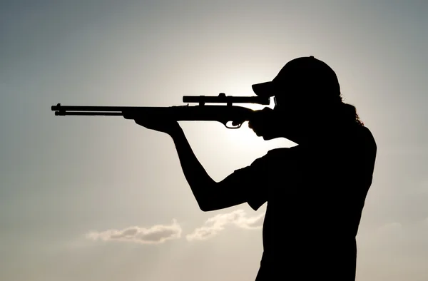 Silhouette di un giovane uomo con coda di cavallo che spara contro il tramonto — Foto Stock