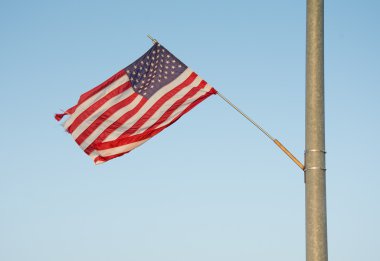 Bize akşam güneşi sallayarak bir sokak ışık küçük bir kırsal kasabada bağlı bayrak