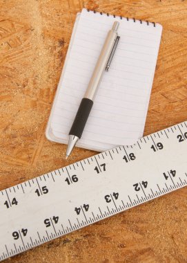 Düz kenarlı, not defteri ve kalem kontrplak, bir yapı veya diğer ahşap çalışması için planlama kavramı üzerine devam eden iş