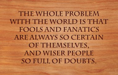 The whole problem with the world is that fools and fanatics are always so certain of themselves, and wiser people so full of doubts - quote on wooden red oak background clipart