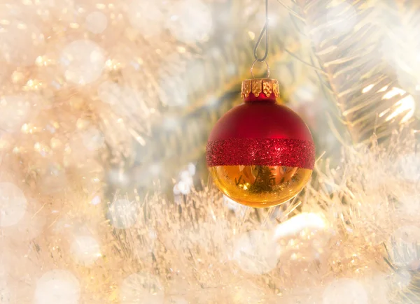 Мечтательный образ рождественской безделушки в красном и золотом на елке — стоковое фото