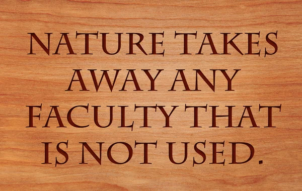 Природа забирает любой факультет, который не используется - цитата на деревянном фоне из красного дуба — стоковое фото
