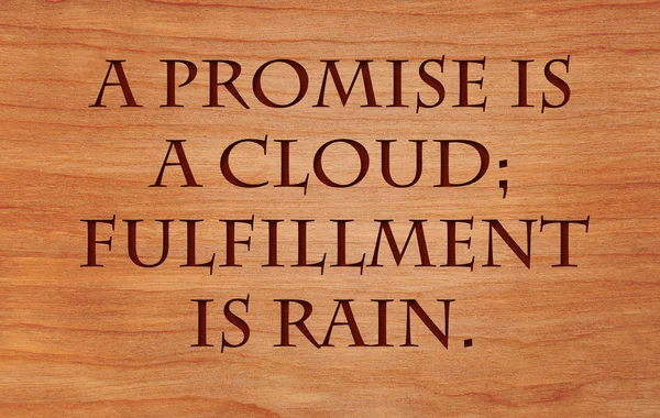 Ein Versprechen ist eine Wolke, Erfüllung ist Regen - ein arabisches Sprichwort, auf rotem Eichenholzgrund — Stockfoto
