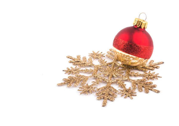 Christmas bauble resting on a golden snowflake on white — Stock Photo, Image